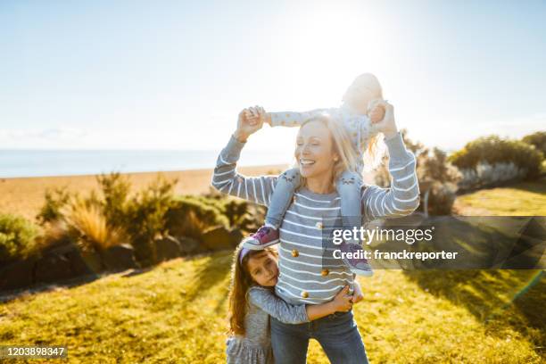 woman piggyback her daughter at summer - aunt niece stock pictures, royalty-free photos & images