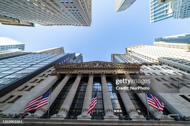 Exterior of New York Stock Exchange Building with classical architecture of Greece columns and US flags as seen during the day, NYSE Financial...