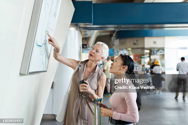 senior woman reading map at railroad station - project traveller stock pictures, royalty-free photos & images