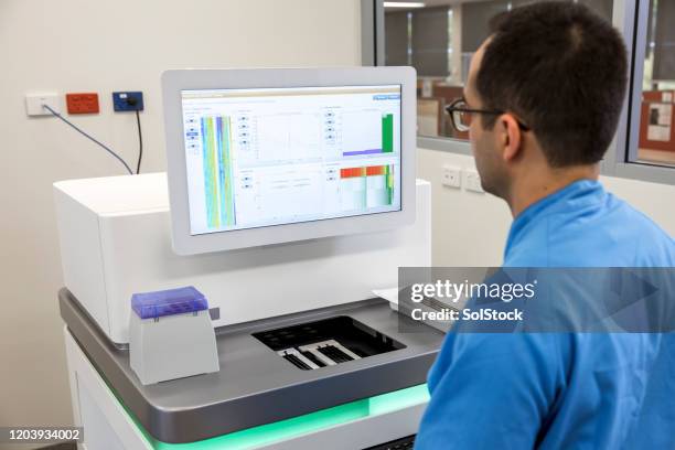 un scientifique masculin observe des données - dépistage des cancers photos et images de collection