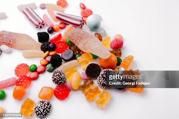 concept no sweets, colorful candies, jelly and marmalade on white background. flat lay, top view - chocolate top view stock-fotos und bilder