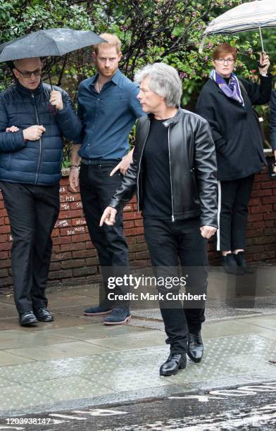 Prince Harry, Duke of Sussex and Jon Bon Jovi walk across the famous Zebra Crossing with members of the Invictus Games Choir at Abbey Road Studios on...