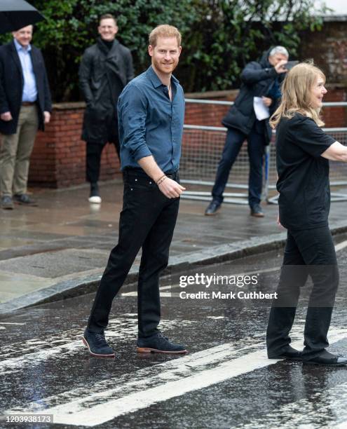 Prince Harry, Duke of Sussex walks across the famous Zebra Crossing with members of the Invictus Games Choir at Abbey Road Studios on February 28,...