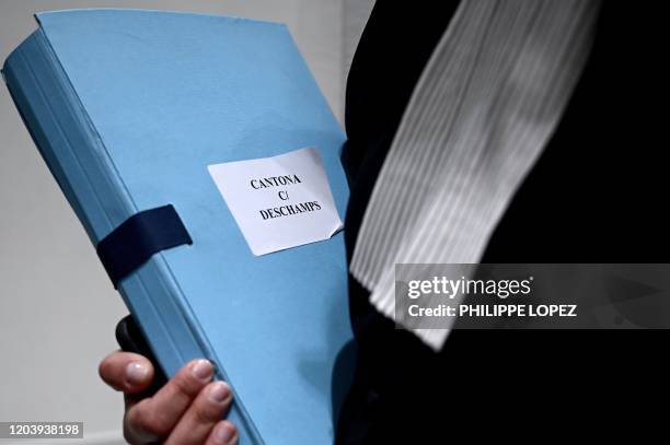 Lawyer carries a file of the case opposing former French football player Eric Cantona and French football team head coach Didier Deschamps at Paris...