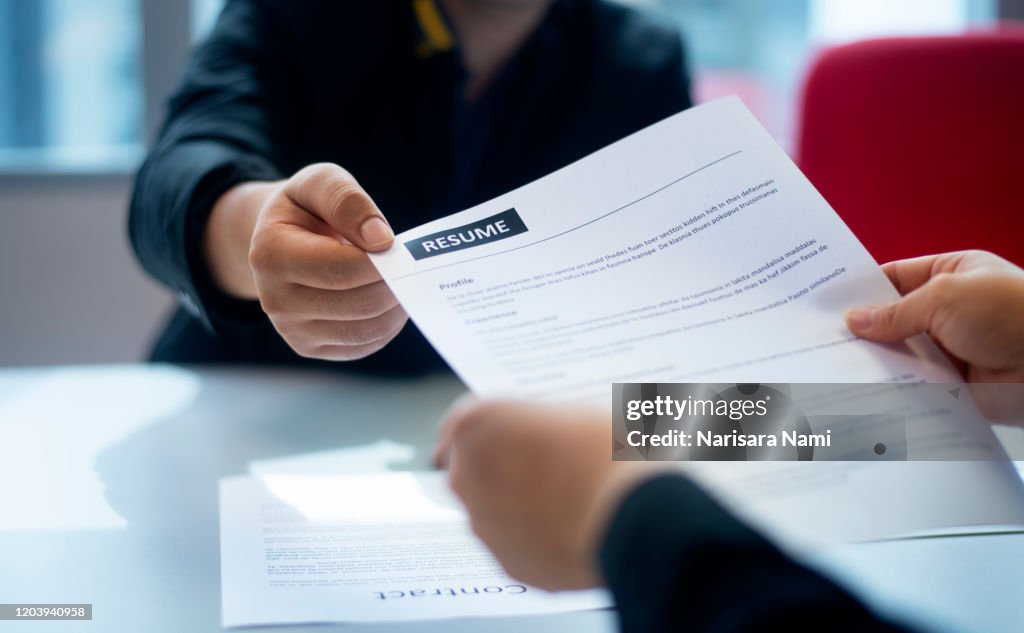 Recruitment, Job application, contract and business employment concept. Hand giving the resume to the recruiter to review the profile of the applicant.