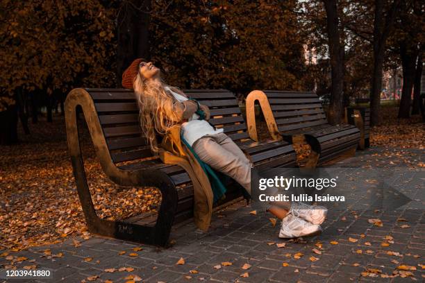 satisfied young woman enjoying autumn in park - life events foto e immagini stock