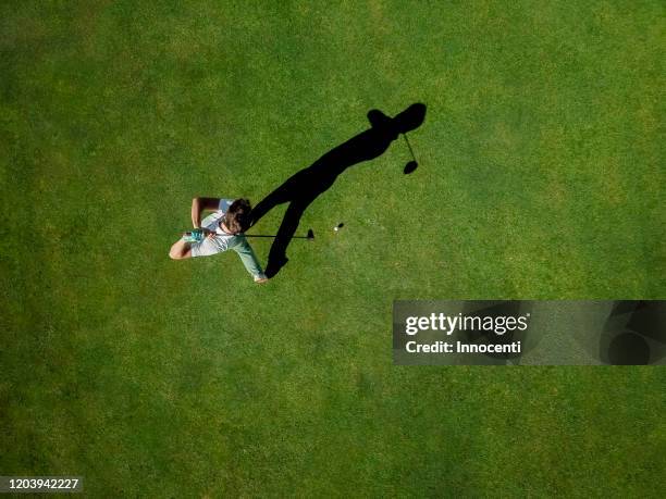 man playing golf on golf course - green de golf photos et images de collection