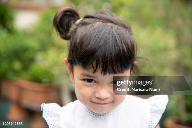 asian little cute shy girl smiling with happiness. face expression concept. - timido foto e immagini stock