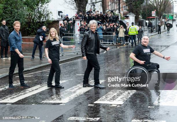 Prince Harry, Duke of Sussex and Jon Bon Jovi walk across the famous Zebra Crossing with members of the Invictus Games Choir at Abbey Road Studios on...