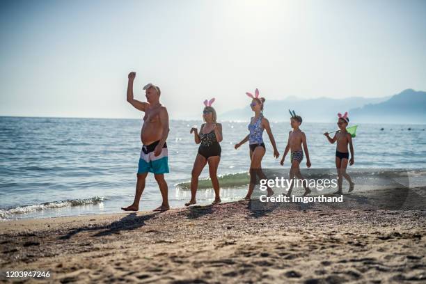 family enjoying easter on beach - italian easter stock pictures, royalty-free photos & images