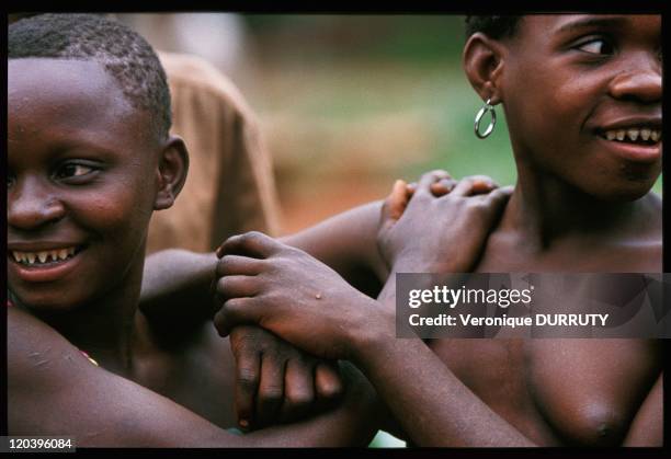 Young Pygmies in Central African Republic - Two young pigmy girls. For esthetical reasons, pygmies cut their teeth into points. The earrings has been...