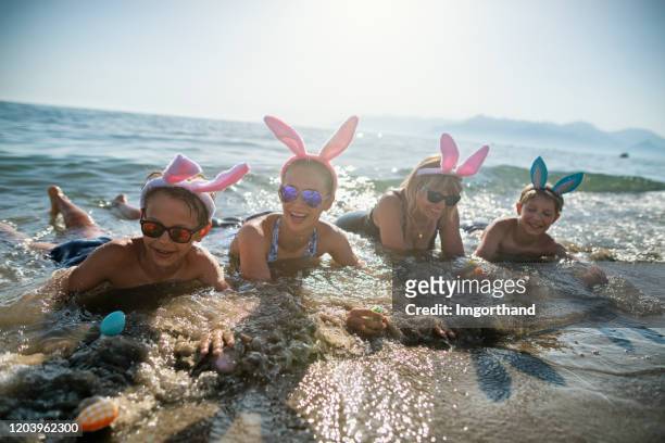 夏季復活節期間，孩子們和祖母在海裡玩耍 - happy easter in italian 個照片及圖片檔
