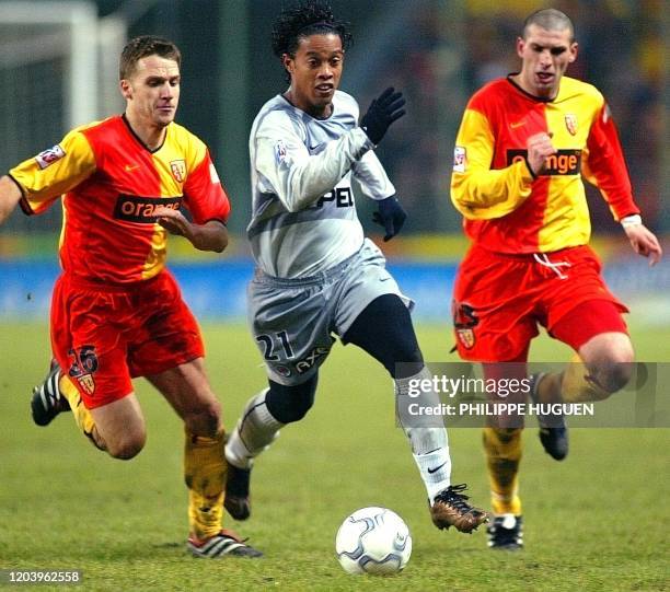 Les joueurs de Lens Bruno Rodriguez et Valérien Ismaël tente de contrer l'attaquant du Paris-SG Ronaldinho , le 24 Janvier 2002 au stade...