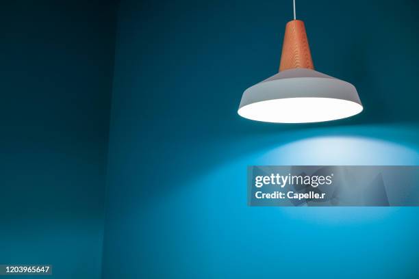 art abstrait - luminaire moderne et mur bleu canard - mur bleu stock pictures, royalty-free photos & images