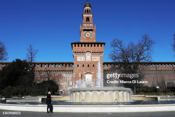 Tourist takes a selfie in an empty square in front of the Sforza Castle on February 28, 2020 in Milan, Italy. Italy registered a 25% surge in...