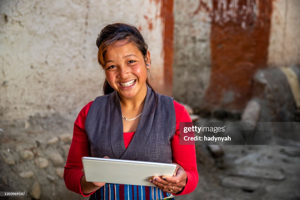 Tibetan young woman using digital tablet, Upper Mustang, Nepal
