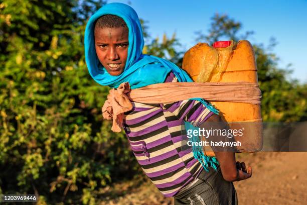 african girl carrying water from the river, ethiopia, africa - thirsty stock pictures, royalty-free photos & images