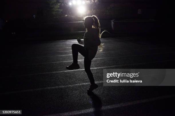 young woman training on stadium at night - track and field stadium 個照片及圖片檔
