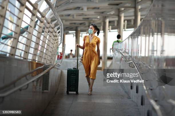 Woman walking with luggage at railroad station