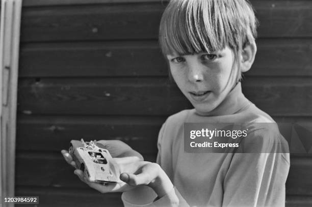 Competitor holding up one of the model cars taking part in the toy car Grand Prix, 24th September 1973.