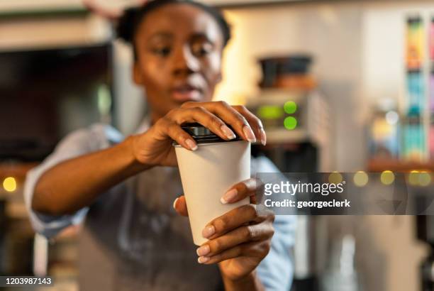 putting the lid on a coffee takeaway - coffee cup takeaway stock pictures, royalty-free photos & images