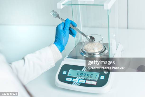 female scientist measuring chemical substance on laboratory scale - science measurement stock pictures, royalty-free photos & images