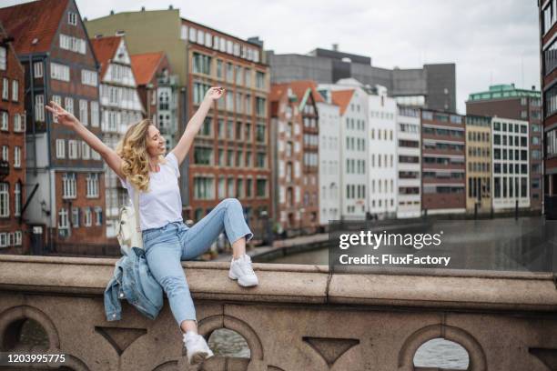 happy blond girl resting on a bridge - hamburg germany stock pictures, royalty-free photos & images