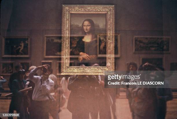 The Mona Lisa at the Louvre Museum, in Paris, France in October, 2001 - The Mona Lisa behind its bullet-proof glass protection with Japanese tourists...