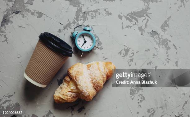 take away coffee in paper cup, retro alarm clock and croissant over gray background - coffee take away cup simple imagens e fotografias de stock