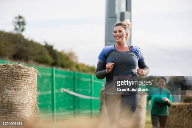smiling woman leading outdoor charity run - charity and relief work stock pictures, royalty-free photos & images