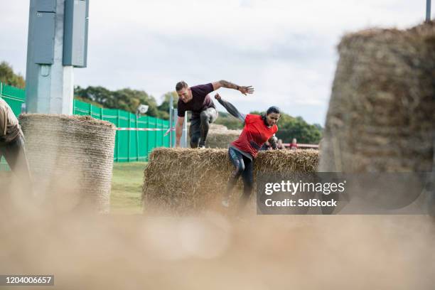 athletic woman jumping hay bales in stampede race - conquering adversity stock pictures, royalty-free photos & images