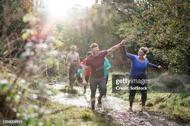 gelukkig paar viert het voltooien van dwars landras - survivor stockfoto's en -beelden