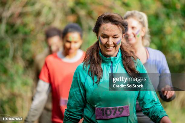 muddy woman on charity run in country park - fundraising stock pictures, royalty-free photos & images