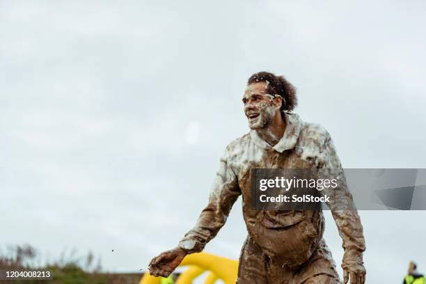 cheerful man covered in mud at outdoor charity event - people covered in mud stock pictures, royalty-free photos & images