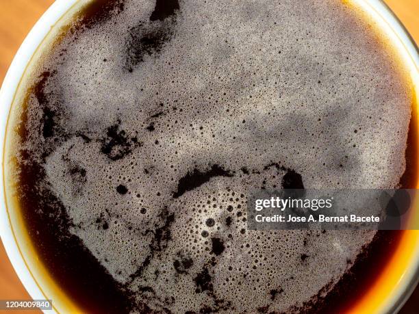full frame of foam from a freshly brewed espresso cup, backgrounds. - milk swirl stock pictures, royalty-free photos & images