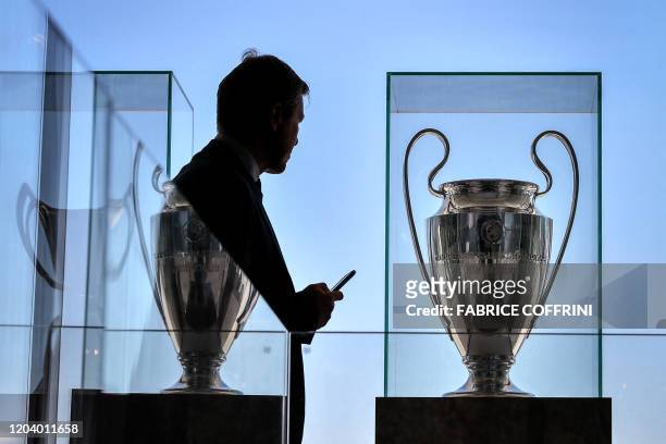Man looks on as the UEFA Champions League trophy is displayed at the UEFA headquarters on February 28, 2020 in Nyon.