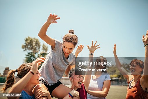 Fußballerinnen feiern Sieg auf Fußballplatz Fußballerinnen feiern Sieg auf Fußballplatz