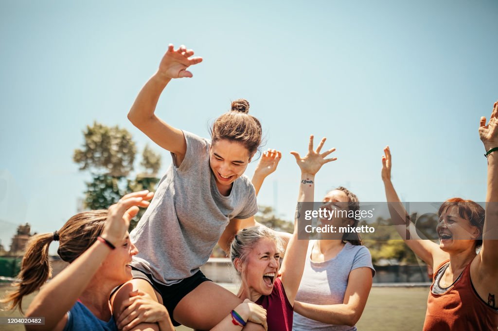 Female soccer players celebrating victory on soccer field