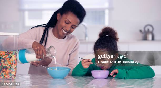 moeder en dochter die ontbijtgranen voor ontbijt eten. - moeder kind zes melk stockfoto's en -beelden