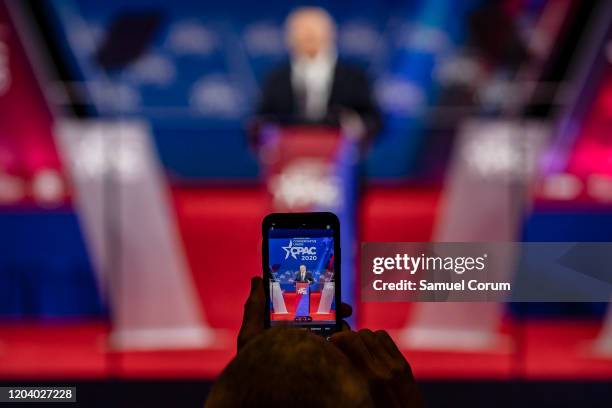 An attendee takes a photograph on their cellphone of Secretary of State Mike Pompeo speaking at the Conservative Political Action Conference 2020...