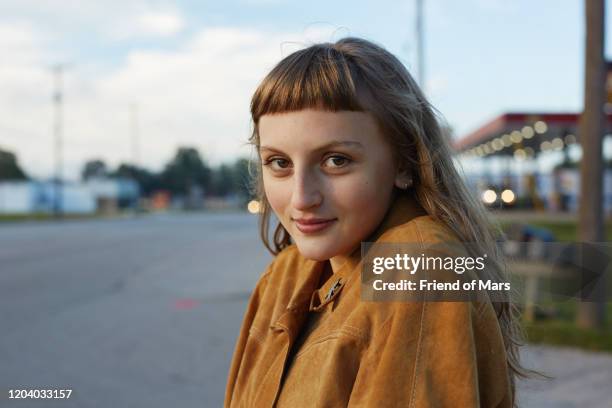 girl with bangs looks into camera in street early morning in mid west - hipster man stock-fotos und bilder