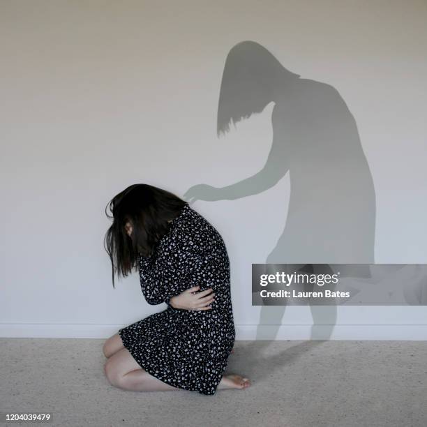 sad woman with a supportive shadow - scary shadow stock pictures, royalty-free photos & images