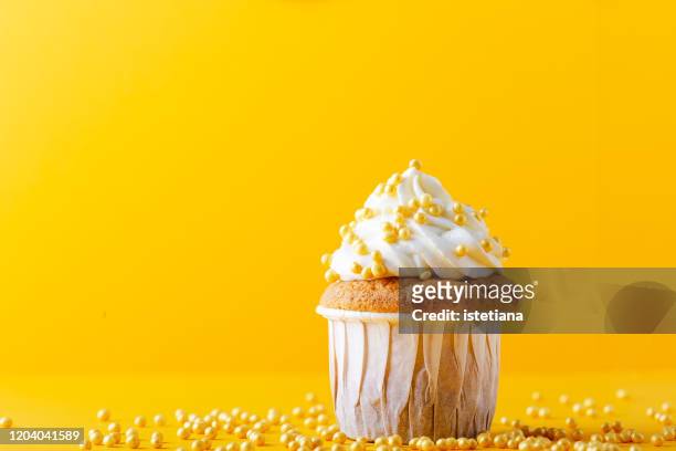 food celebration, one cupcake with sprinkles on yellow background - cupcake stock pictures, royalty-free photos & images