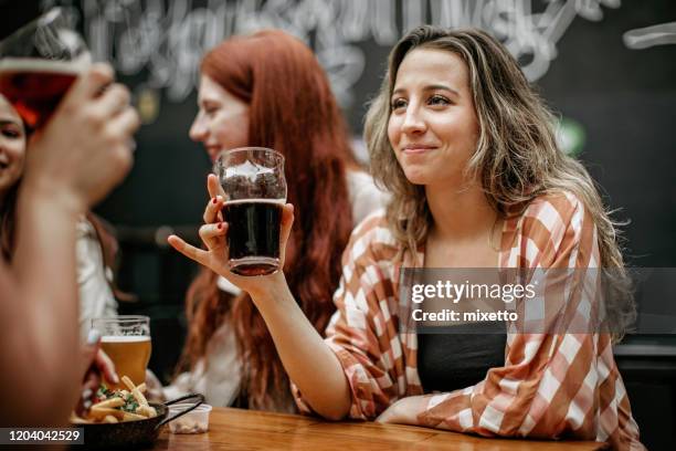 beautiful woman enjoying beer with friends at outdoor cafe - beer nuts stock pictures, royalty-free photos & images