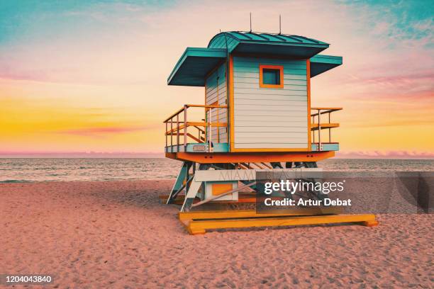 colorful miami beach lifeguard tower with stunning sunset sky and empty beach. - hut stockfoto's en -beelden