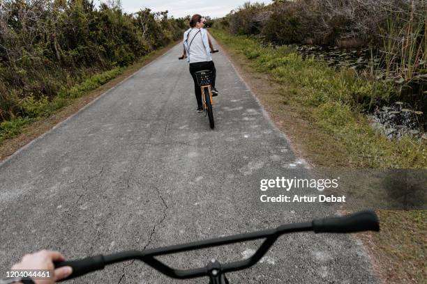 couple sightseeing animals in the everglades national park riding bicycles. - miami fahrrad stock-fotos und bilder