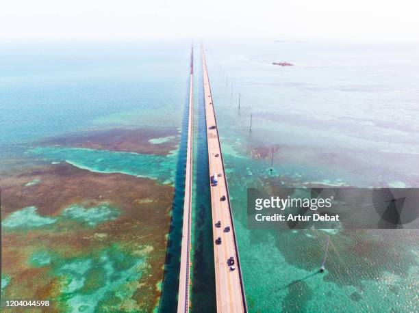 drone view of the overseas highway in florida keys with turquoise watercolor and infinite road. - the florida keys stock pictures, royalty-free photos & images
