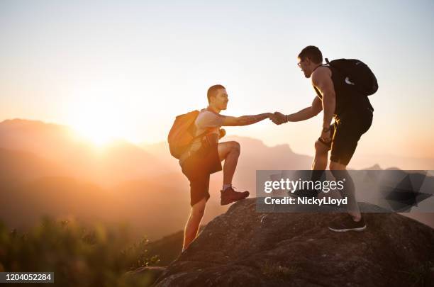 wandelen is een groot avontuur - team climbing up to mountain top stockfoto's en -beelden