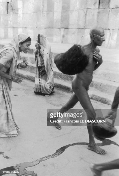 Shravanabelagola, India in 2006 - Naked Jain monk walking in the road in front of women who are bowing down before him at Karnakata, during the...