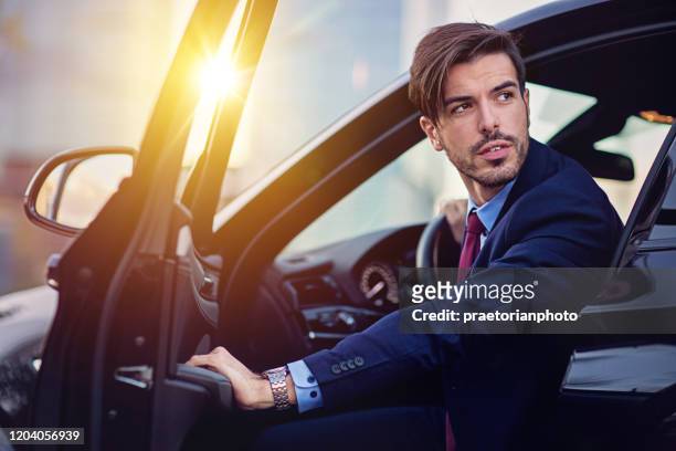 businessman is entering/exiting his car - entering stock pictures, royalty-free photos & images